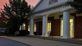 The Rappahannock County Public Library at dusk, its windows lit from inside.